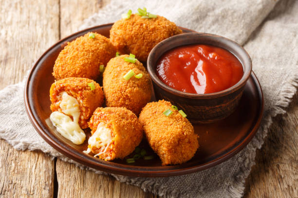 Italian Supplì on a wooden table with a grey linnen under the brown plate.