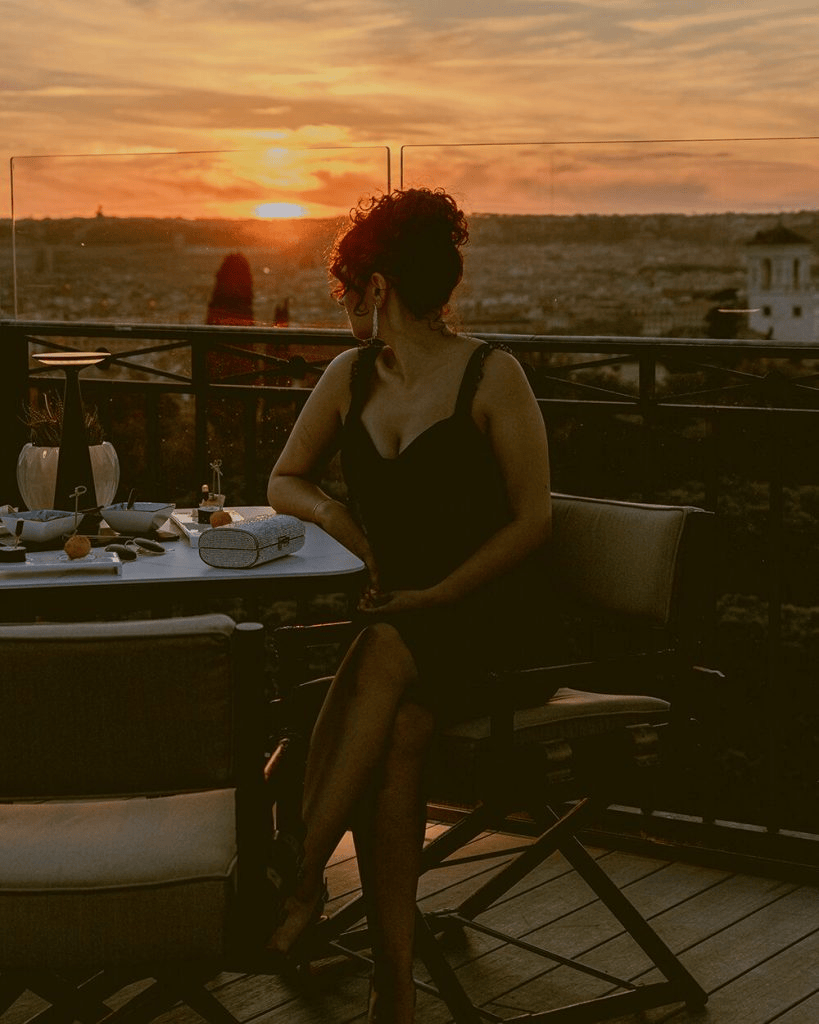 Rooftop bar in Rome. Italy, with a beautiful brown skinned girl during the sunset.