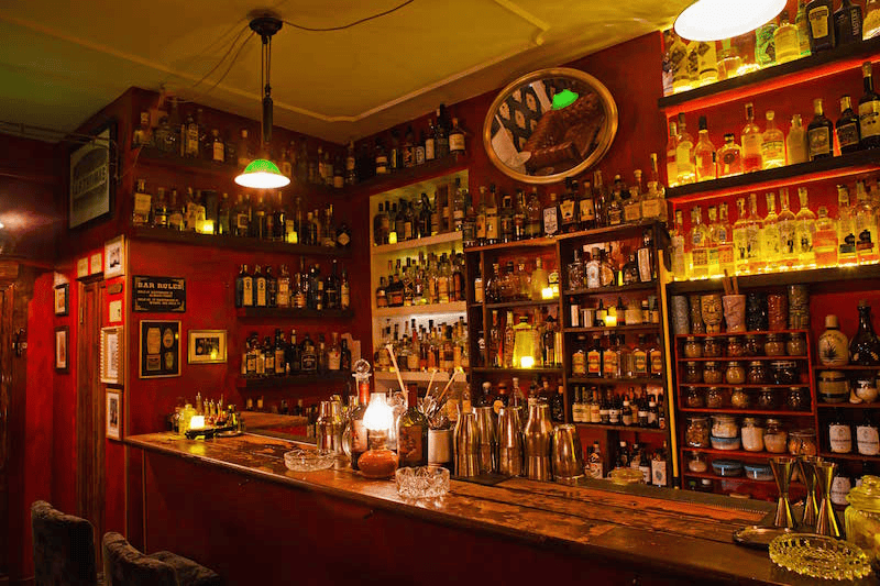 Jerry Thomas Speakeasy cocktail bar in Rome, Italy, with the red background behind the bar.
