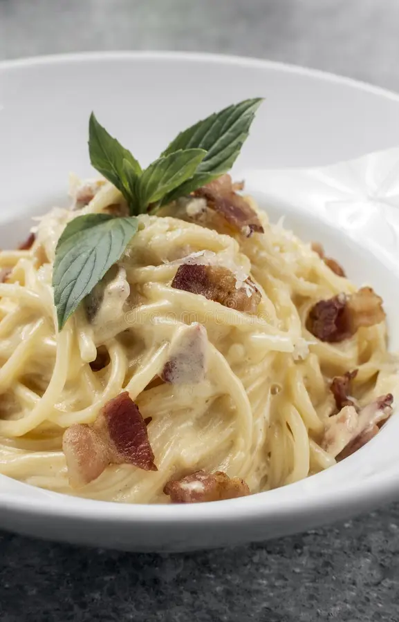 White plate with a Italian made pasta carbonara.